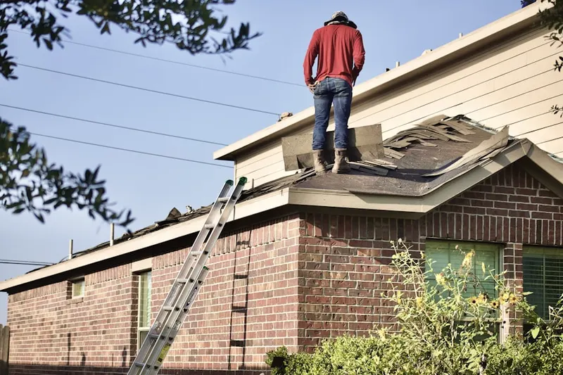 Professional roofer working on a residential roof in College